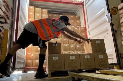 Warehouse Employee stacking parcels on a pallet for Transload.