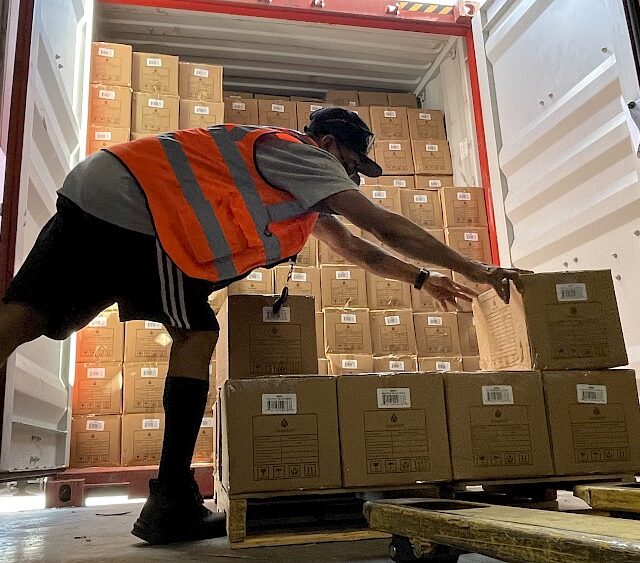 Warehouse Employee stacking parcels on a pallet for Transload.