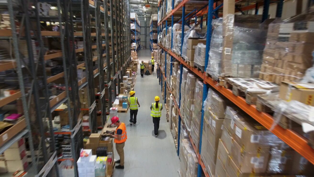 Team at warehouse checking inventory and transporting boxes