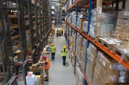 Team at warehouse checking inventory and transporting boxes