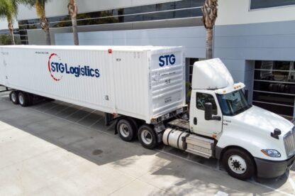 Motor Carrier Success Capture - STG Truck and intermodal container in front of Warehouse.
